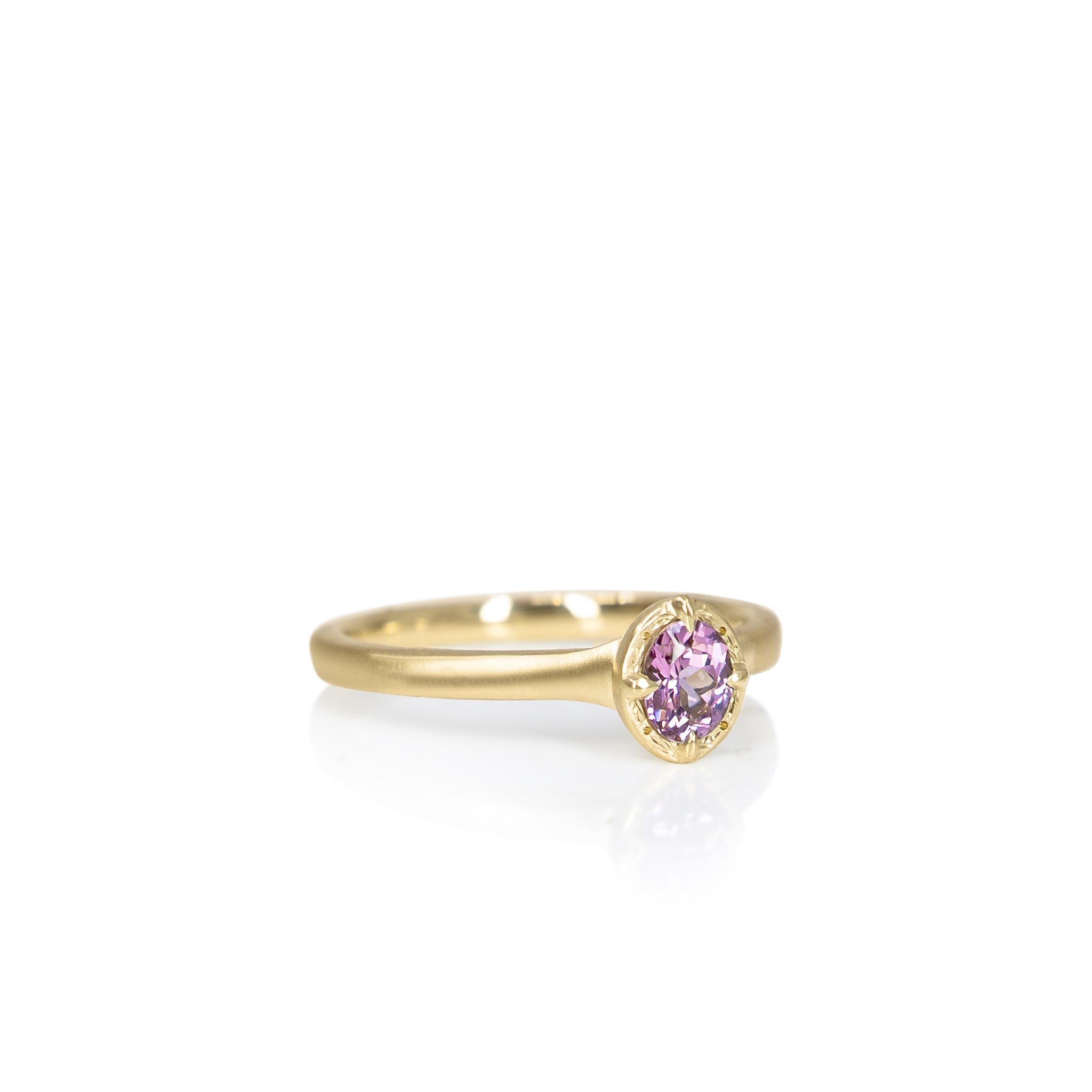 Gold ring with a pink gemstone on a white background