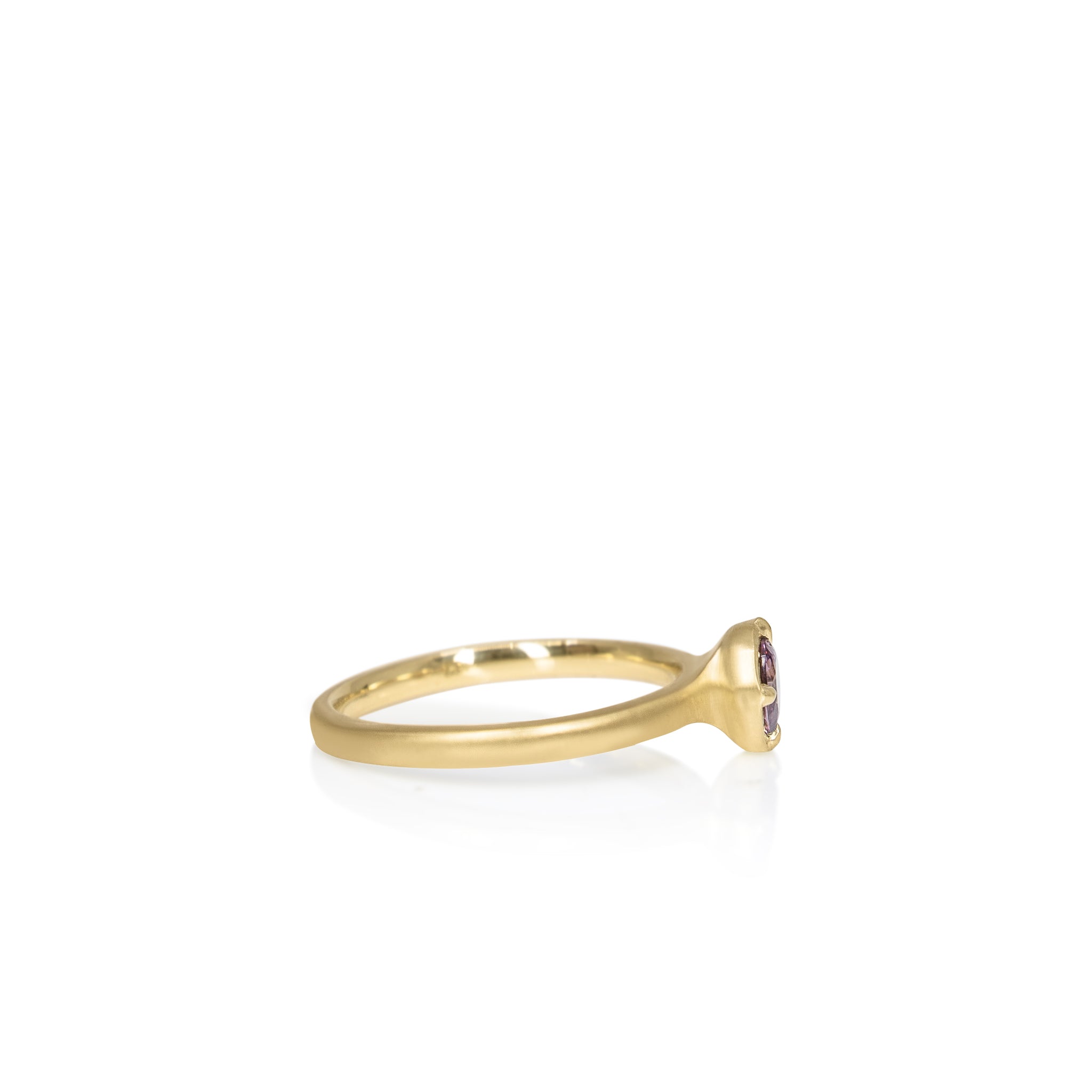Gold ring with a small gemstone , sideview on a white background