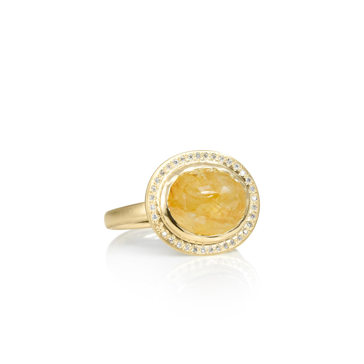 Gold ring with a yellow gemstone on a white background