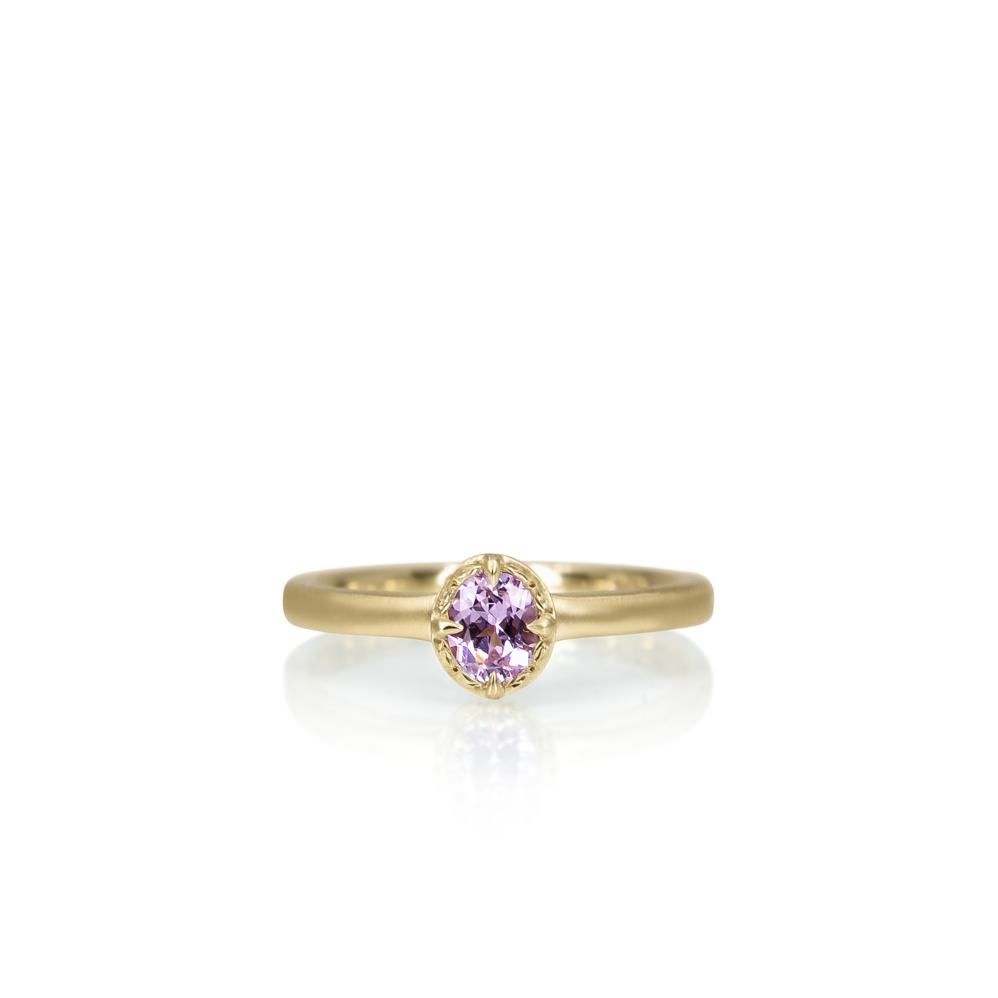 Gold ring with a purple gemstone on a white background