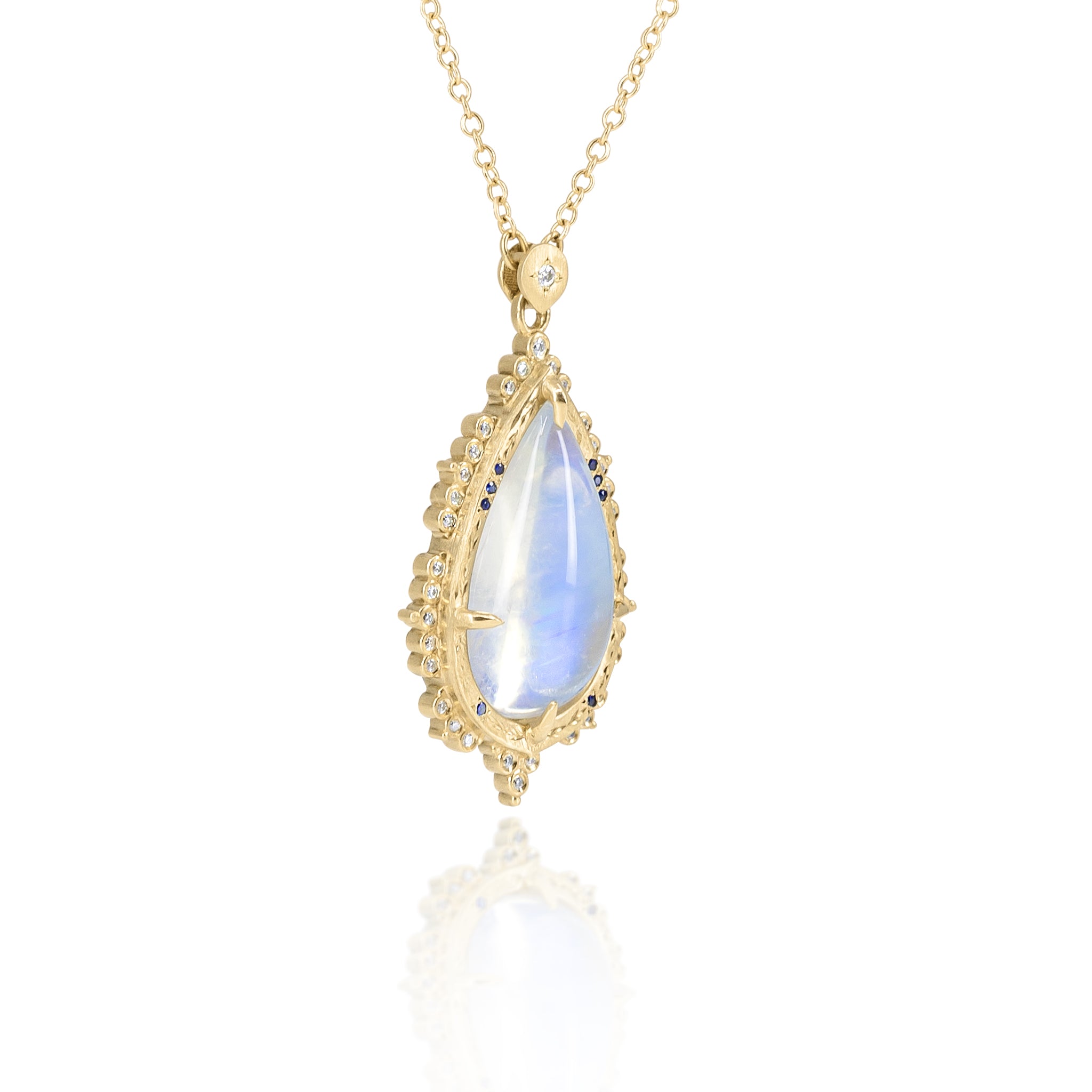 Gold necklace with a teardrop-shaped blue gemstone pendant on a white background